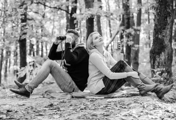 Casal no amor turistas relaxante manta de piquenique. Homem com binóculos e mulher com caneca de metal desfrutar de parque natural. Encontro no parque. Relaxando no parque juntos. Feliz casal amoroso relaxar no parque juntos — Fotografia de Stock