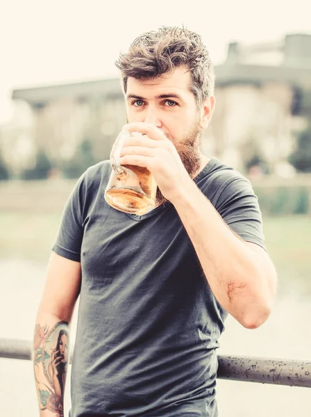 Un hombre bebiendo cerveza. Hombre barbudo con vaso de cerveza al aire libre. macho brutal necesita refresco. Beber cerveza alcohólica. fin de semana relajarse. maduro hipster con barba pelo bebiendo cerveza — Foto de Stock