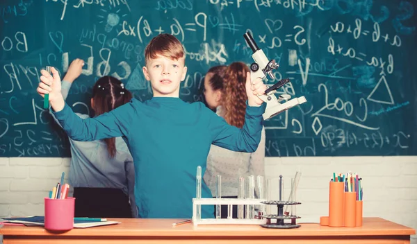 Kinder studieren in der Schule Biologie und Chemie. Schulbildung. Eigene Forschung. Erforschung biologischer Moleküle. Zukunftskonzept für Technologie und Wissenschaft. Junge halten Mikroskop und Reagenzglas im Klassenzimmer — Stockfoto