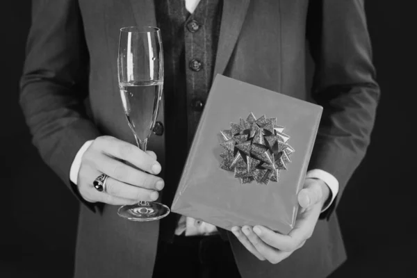 Businessman in retro suit holding gift box and champagne — Stock Photo, Image