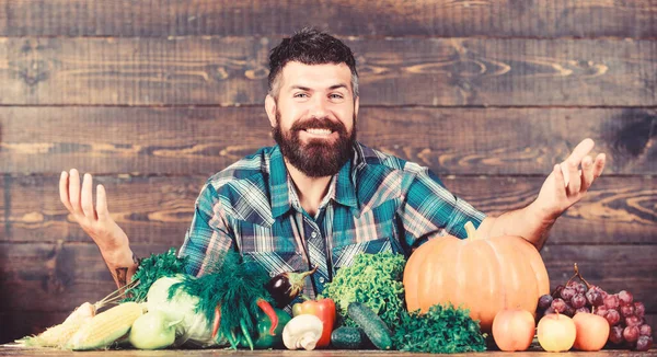 Çiftçi köylü tarzı adam. Doğal gıdalar. Vejetaryen yaşam tarzı konsepti. Sakallı çiftçi ahşap arka plan hasat ediyor. Çiftliğime hoş geldiniz. Evde yetişen sebzeli çiftçi. Sebzeler organik hasat
