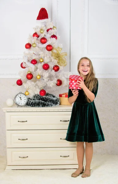 Child celebrate christmas at home. Favorite day of the year. Time to open christmas gifts. Opening christmas presents. Dreams come true. Surprise concept. Kid girl near christmas tree hold gift box — Stock Photo, Image
