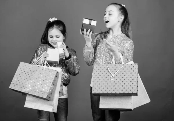 ブラックフライデー販売と割引。買い物の日。子供たちはパッケージを束ねています。キッズファッション。女の子の姉妹は、ショッピングバッグ青い背景を持つ友人。すべての製品があなたに配信されます。ショッピングと購入 — ストック写真