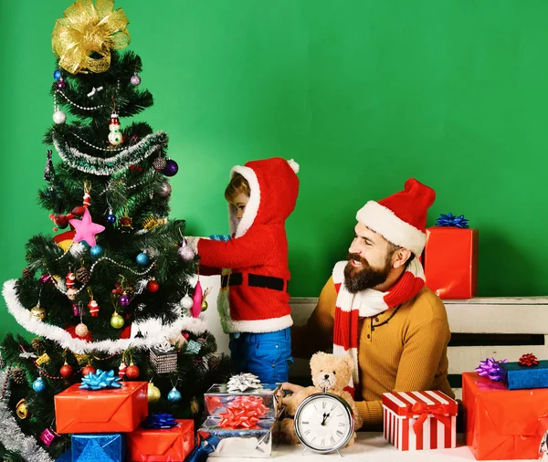 Père Noël et petit assistant parmi les coffrets cadeaux. — Photo