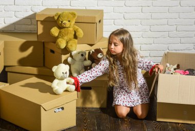 Lüks ve Lüksün Buluştuğu Yer. Oyuncağı olan mutlu küçük bir kız. Yeni bir yaşam alanı satın almak. Yeni evimizde oynuyoruz. Yeni daire. Mutlu çocuk karton kutusu. Karton kutular - yeni eve taşınıyor