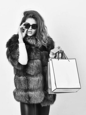 Alışveriş veya doğum günü hediyesi. Kız giyim güneş gözlüğü ve kürklü ceket alışveriş beyaz arka plan. Kadın alışveriş lüks butik. Bayan alışveriş torbaları kalın. İndirim ve satış. Siyah Cuma günü indirim ile satın
