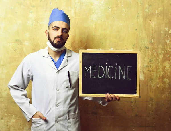 Guy σε ιατρική στολή κατέχει πίνακα με λέξη ιατρική — Φωτογραφία Αρχείου