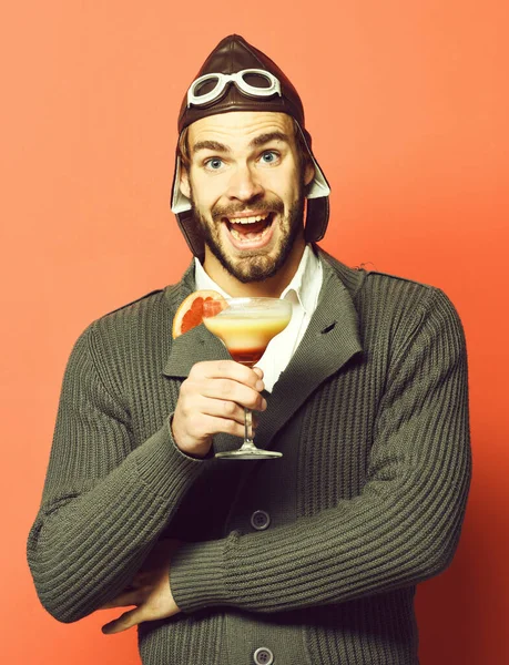 Skäggig pilot med cocktail i glas på röd studio bakgrund — Stockfoto
