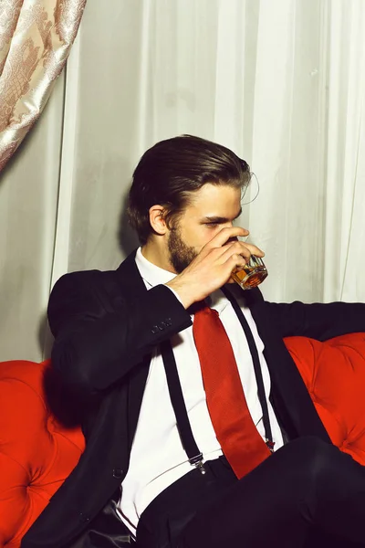 Vousatý muž, obchodník se sklenicí whisky v červené kravatě — Stock fotografie