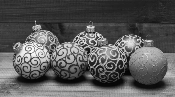 Ideazione delle decorazioni natalizie. Scegli decorazioni colorate. Arredo natalizio moderno. Palle con brillantini e scintillanti ornamenti decorativi. Ornamenti natalizi decorazioni su sfondo vintage in legno — Foto Stock