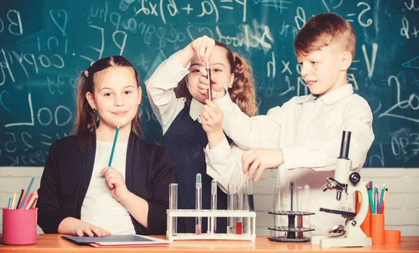 Los alumnos estudian química en la escuela. La sustancia química se disuelve en otra. Los niños disfrutan del experimento químico. Explorar es tan emocionante. La reacción química ocurre cuando la sustancia se transforma en nuevas sustancias — Foto de Stock