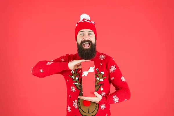 Concepto de regalo de Navidad. Compra algo de la lista de deseos. Regalo de Navidad. El tipo usa sombrero de invierno. Feliz Navidad y feliz año nuevo. Hombre guapo celebrar las vacaciones de invierno fondo rojo. Compras de Navidad — Foto de Stock