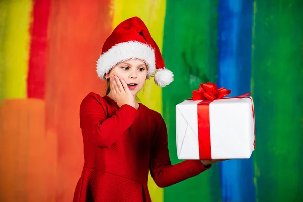 意想不到的惊喜新年假期的惊喜。每个人都会得到一份礼物。穿着圣塔服装的小女孩。买东西的小孩圣诞节购物和销售。圣诞节派对惊喜。寒假气氛 — 图库照片