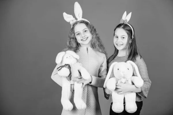 Hope love and joyful living. Friends little girls with bunny ears celebrate Easter. Children with bunny toys on blue background. Sisters smiling cute bunny costumes. Spread joy and happiness around — Stock Photo, Image