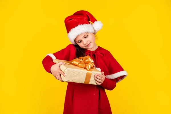 Våra traditioner. Leksaksaffär och presenter till barn. Ett leende barn i tomteluva. Låt julen vara ljus. barndoms lycka. liten nisse hålla presentförpackning. Förberedelser inför det nya året. Julklappsshopping — Stockfoto