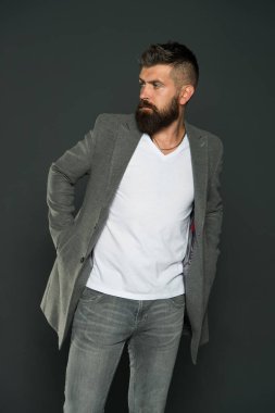 Hiçbir erkek şık doğmaz. Tarz sahibi iş adamı gri arka plan. Vahşi görünüşlü, sakallı bir adam. Sıradan ama şık. Moda ve tarz trendleri. İş hayatı