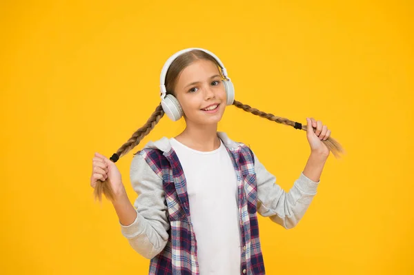 무선 기술 이 있는 헤드폰. 어린 아이가 현대 무선 이어폰으로 음악을 듣고 있습니다. 현대 헤드폰을 끼고 있는 행복 한 소녀. 귀여운 아이가 스테레오 소리를 즐기고 있습니다. 무선은 자유를 의미 한다 — 스톡 사진