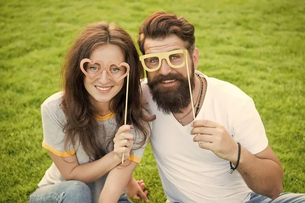 Homem barbudo hipster e mulher bonita apaixonada. Férias. Felizes juntos. Casal no amor adereços de cabine de jovens alegres. Casal emocional irradiando felicidade. História de amor. Casal relaxante gramado verde — Fotografia de Stock