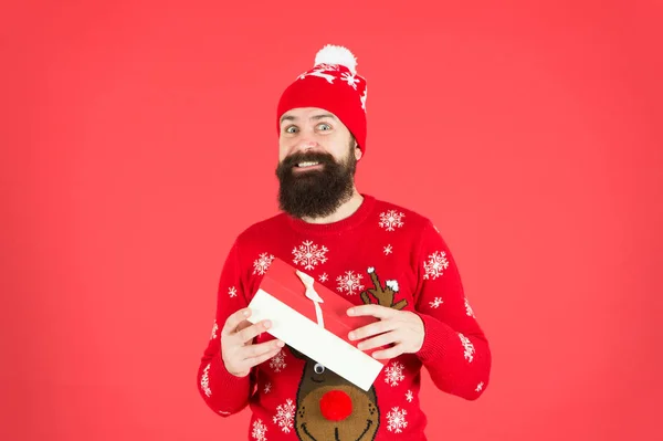 Bel homme célébrer vacances d'hiver fond rouge. Concept de cadeau de Noël. Il porte un chapeau d'hiver. Les courses de Noël. Secret Santa pourrait soulager le stress des vacances. Joyeux Noël et bonne année — Photo