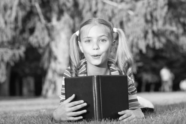 Adorable bookworm. School time. Developing caring learners who are actively growing and achieving. Little child reading book. Schoolgirl reading stories relaxing green lawn. Cute pupil enjoy reading — Stock Photo, Image