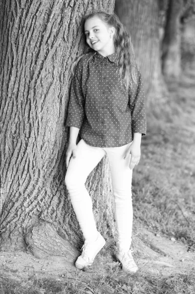 캐주얼 스타일은 하루 종일 편안하고 귀여운 그녀를 유지합니다. 자연에 캐주얼 하루를 위해 옷을 입고 사랑스러운 아이. 나무에 서 캐주얼 한 옷을 입고 행복 한 작은 소녀. 미소 짓는 어린 아이의 캐주얼 룩 — 스톡 사진