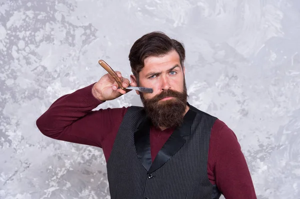 Crear un nuevo peinado. Barbería retro equipos de corte de pelo. cuchilla y afeitadora. un hombre serio con pelo largo facial. brutal maestro de barbería. peluquero barbudo mantenga herramientas de peluquería — Foto de Stock