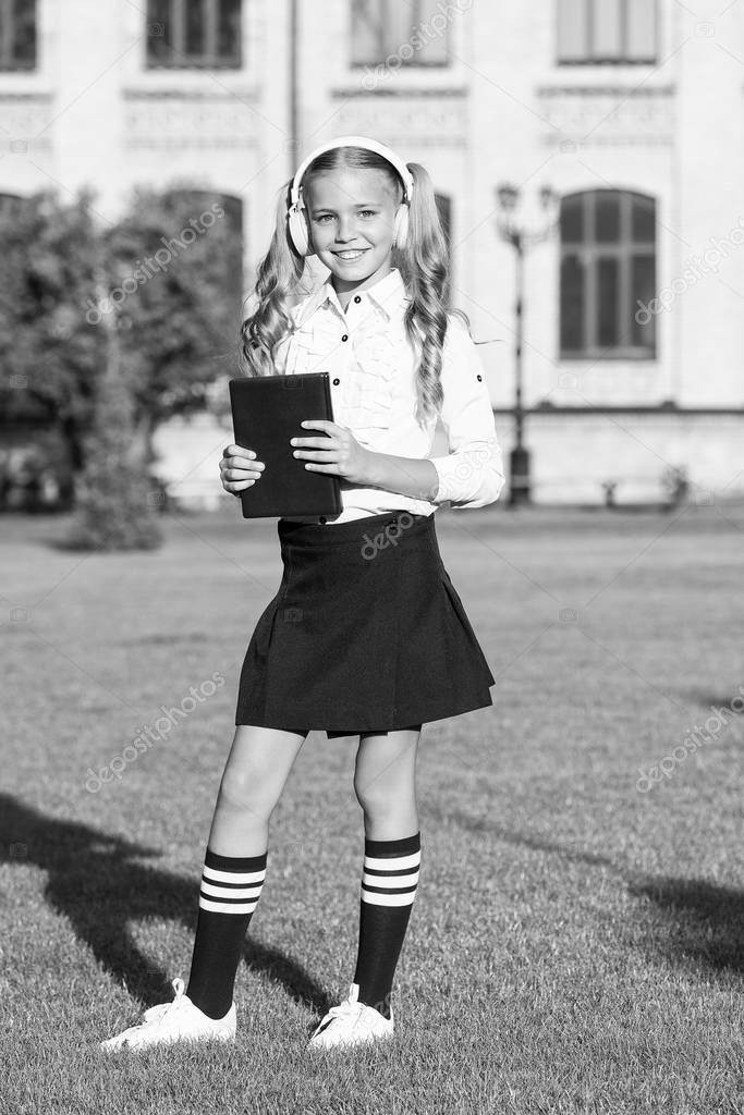 Audio book concept. Listening school book. Digital technologies for learning. Elearning and modern methods. Girl cute schoolgirl hold book and headphones. Knowledge assimilate better this way