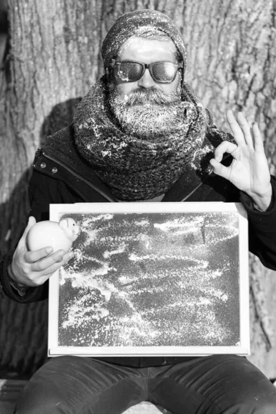 Hombre con tabla y cerdo, alcancía en el día de invierno en el fondo natural —  Fotos de Stock