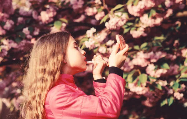 Cheiro a flor macia. Conceito de flor Sakura. Linda flor e beleza feminina. Cosméticos naturais de pele. Menina em flor de cereja. Miúdo com maquilhagem de batom. Menina pequena criança na flor da primavera — Fotografia de Stock