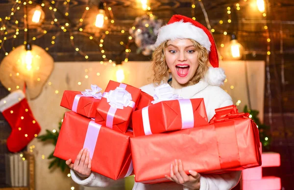 买很多礼品包装。 女孩桑塔帽子拿着包装好的礼品盒. 新年。 如果你有很多礼物要包装，那么就把它变成礼物包装派对。 她应该得到最好的。 彩带蝴蝶结配件 — 图库照片