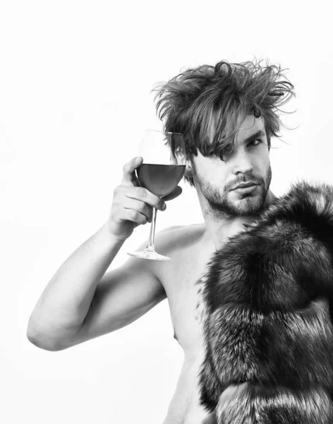 Rijkdom en luxe concept. Rich atleet genieten van zijn leven. Guy aantrekkelijke rijk poseren bontjas op naakte lichaam. Sexy slaperig rijke macho tousled haar drinken wijn geïsoleerd op wit. Gezondheid en welzijn — Stockfoto