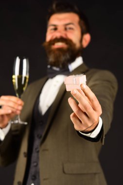 Maço retro elbiseli küçük pembe kutu içecek tutarak sunar.