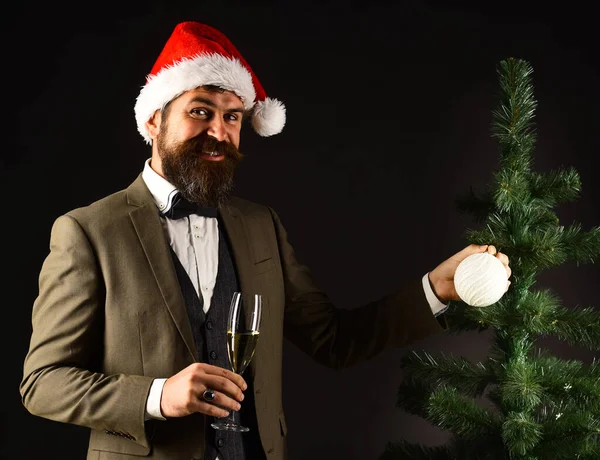 Empresario con sonrisa sostiene champán y bola de árbol . —  Fotos de Stock