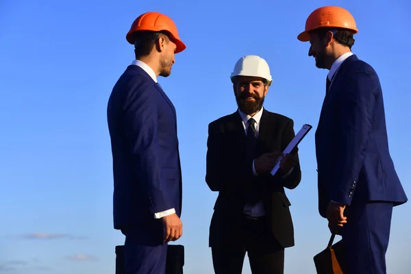 Managers wear smart suits, ties and hardhats