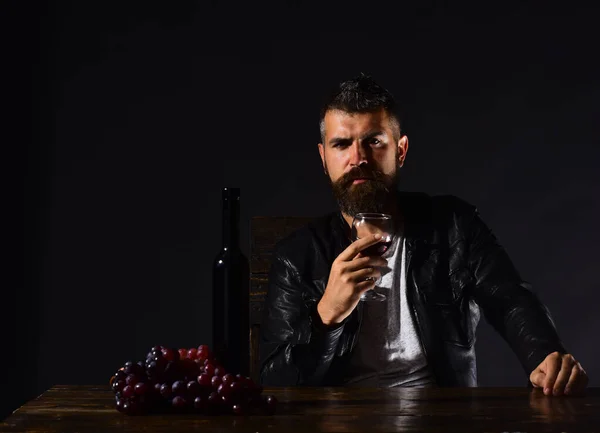 Чоловік з бородою тримає келих вина на коричневому фоні — стокове фото