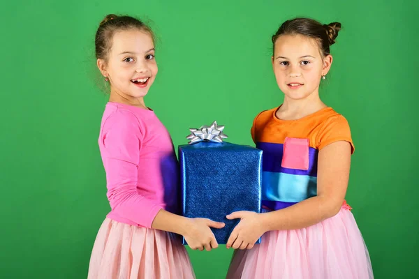 Meninas com rostos felizes posar com presente no fundo verde — Fotografia de Stock