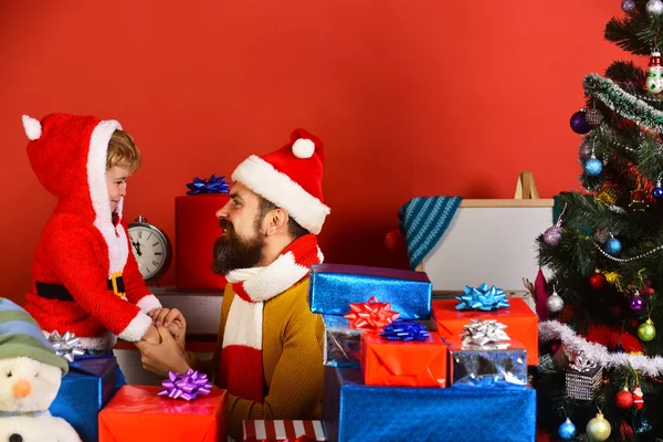 Familia de Navidad abre regalos sobre fondo rojo. —  Fotos de Stock