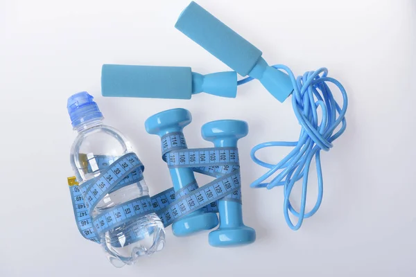 Sombrillas, saltar la cuerda en color cian cerca de la botella de agua —  Fotos de Stock