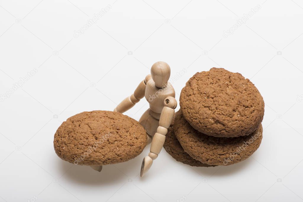 Oatmeal biscuits as tasty pastry with humanlike toy sitting nearby