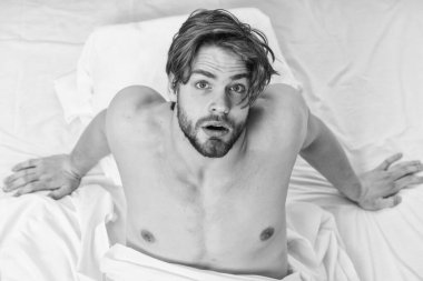 Yatakta uyanma ve kollarını uzanan bir delikanlı. Yakışıklı adam sabah uyanma sonra yatakta kullanarak. Yatakta mutlu adamlar.