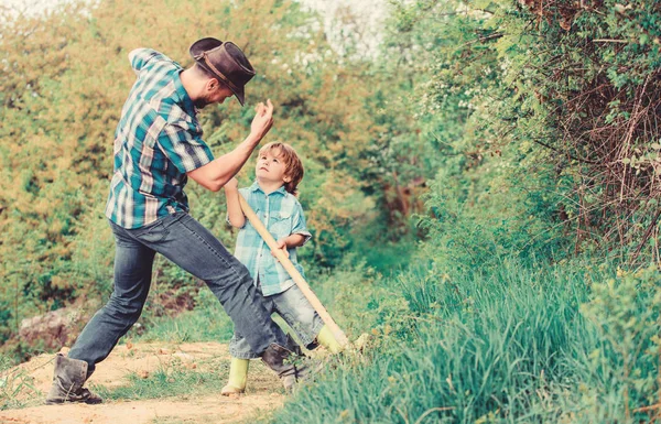 Adventure hunting for treasures. Little helper in garden. Cute child in nature having fun cowboy dad. Find treasures. Little boy and father with shovel looking for treasures. Spirit of adventures