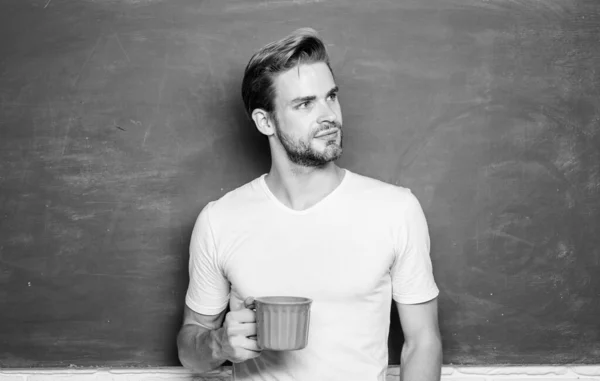 Hombre guapo disfrutar del café caliente. Un adicto al café. Bebida inspiradora. Buenos días. Sip recarga cuerpo y mente. Carga de energía para todo el día. Dosis de cafeína. Profesor beber café pizarra fondo — Foto de Stock