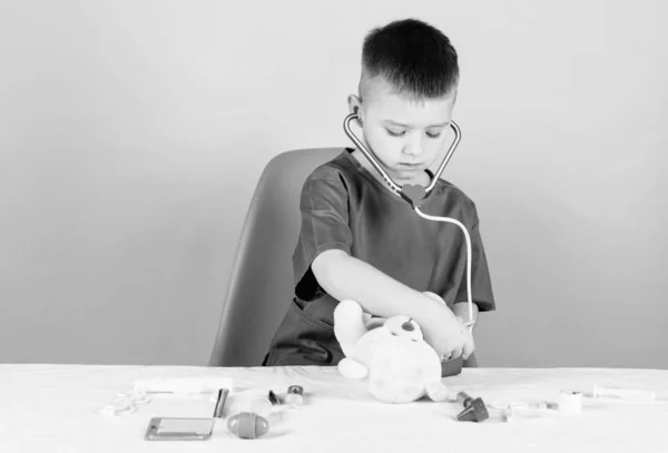 Medical procedures for teddy bear. Medical education. Boy cute child future doctor career. Health care. Kid little doctor busy sit table with medical tools. Medical examination. Medicine concept
