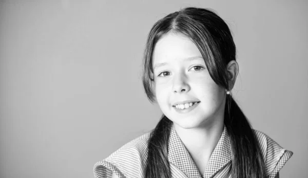 Klein meisje met lang haar. Kind schattig gezicht met schattig haar op roze achtergrond. Schoonheidstips voor netjes haar. Onschuld concept. Gelukkige kinderdag. Pure schoonheid. Meisje lang gezond glanzend haar close-up — Stockfoto