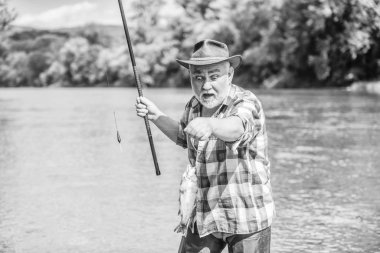 Bu spor değil, saplantı. Kıdemli sakallı adam balık tutuyor. Olgun adam balık tutuyor. Emekli sakallı balıkçı. Oltaya tasnisi olan balıkçı. Aktivite ve hobi. Balıkçılık tatlı su göl gölet nehir