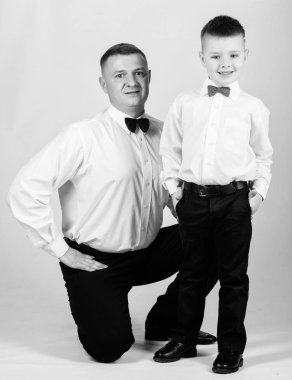 Resmi bir olay. Küçük oğul soylu bir adam babaları örnek takip. Centilmen yetiştirilme tarzı. Baba ve oğul resmi kıyafet kıyafeti. Büyüyün beyefendi. Papyonlu baba ve çocuk. Centilmen yetiştirme