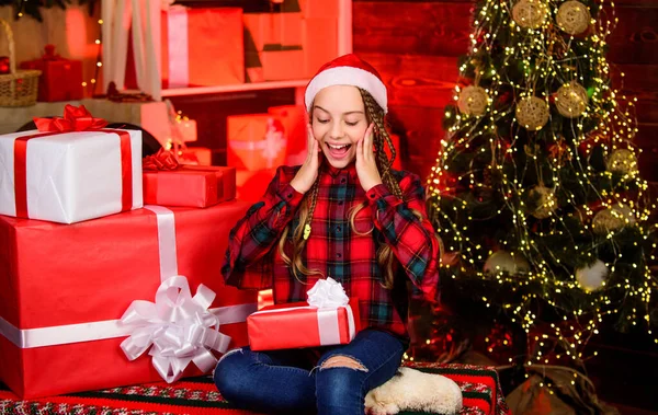 うわ。家族の休日のお祝い。新年明けましておめでとう。赤いサンタの帽子の子供。今の箱の子だ。冬の買い物販売。クリスマスツリーの陽気な女の子。喜びで家を飾る。xmas気分 — ストック写真