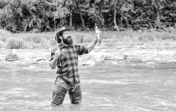 Helg aktivitet. Fiskeutrustning för fiskare. Fisk på kroken. Fisket kräver att du är uppmärksam och fullt närvarande i ögonblicket. Fiske maskulina hobby. Brutal man Wear gummistövlar stand in River Water — Stockfoto