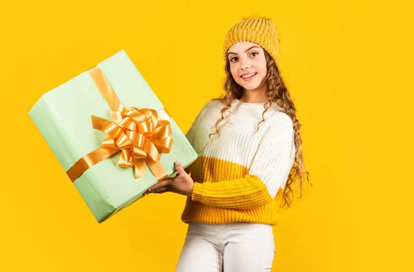 Feliz Año Nuevo para ti. Feliz navidad para ti. descuentos de vacaciones de invierno. niña alegre sombrero de punto y suéter. niño mantenga presente caja de fondo amarillo. Feliz año nuevo. regalo de Navidad venta de compras —  Fotos de Stock