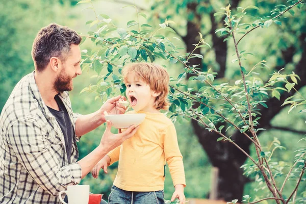 Father son eat food and have fun. Nutrition habits. Little boy and dad eating. Nutrition for kids and adults. Healthy nutrition concept. Feeding baby. Menu for children. Family enjoy homemade meal — Stock Photo, Image